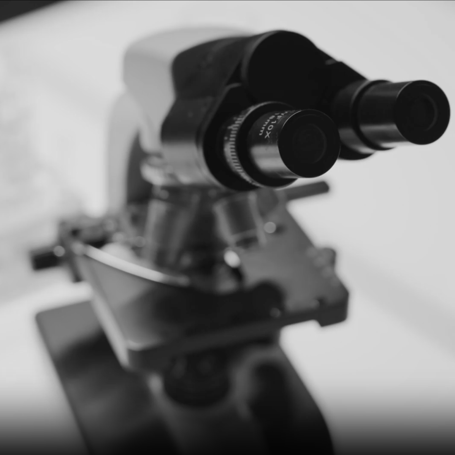 Black-and-white close-up of a laboratory microscope